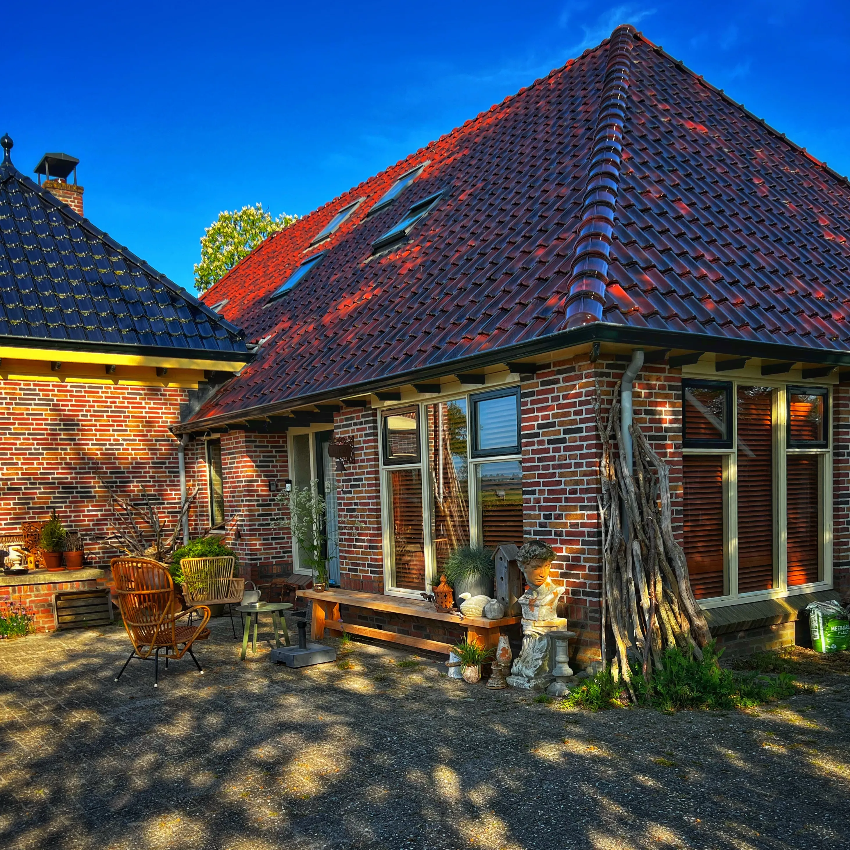 Het erf van B&B Zandhuizen met de karakteristieke boerderij en een zonnig terras