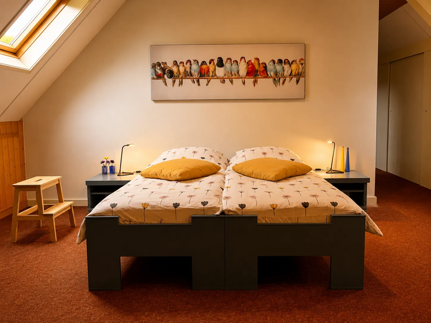 Kamer 1 met zithoek en warm hout onder het schuine dak