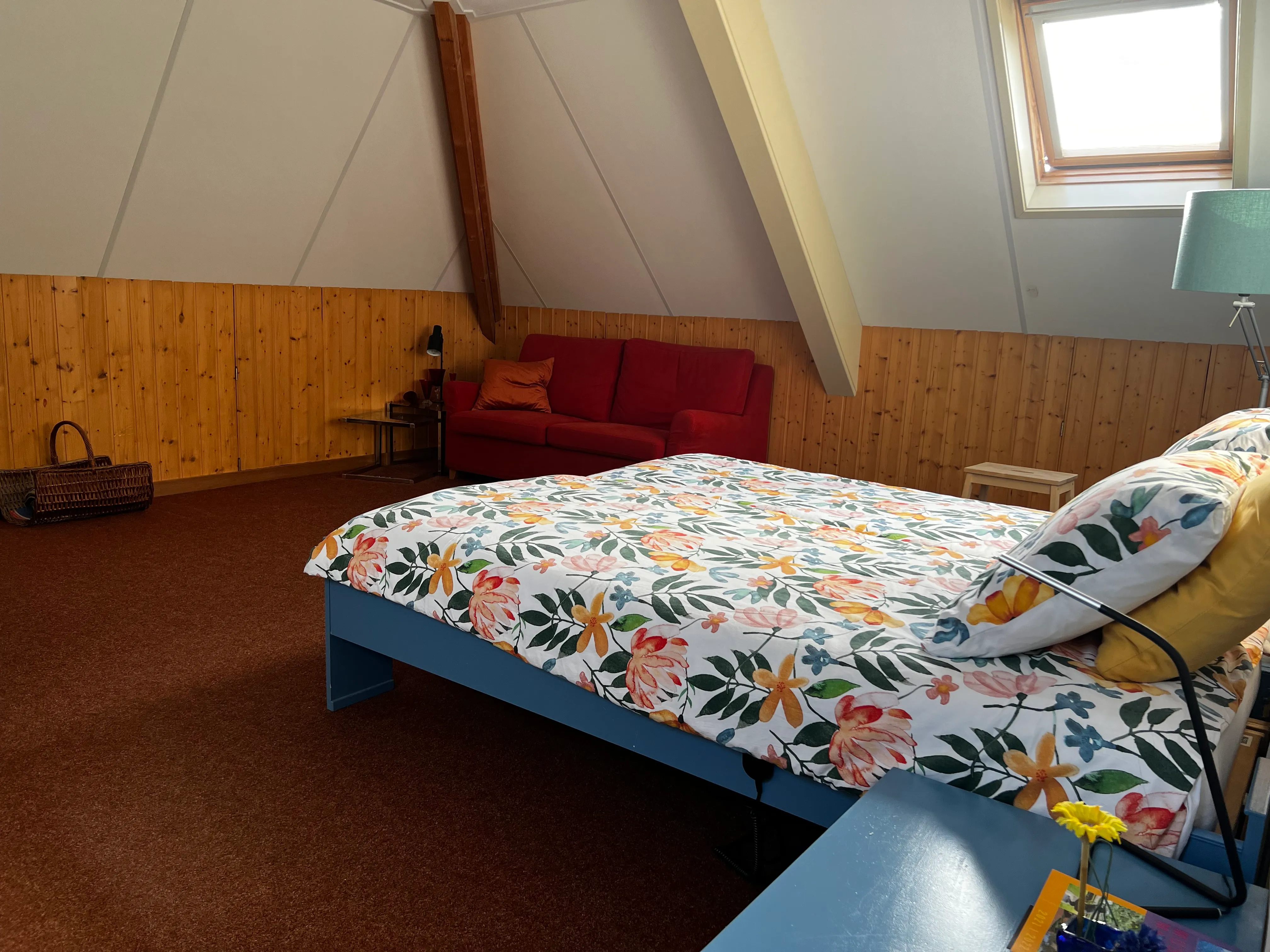 Zicht op het comfortabele bed en de zithoek van Kamer 1
