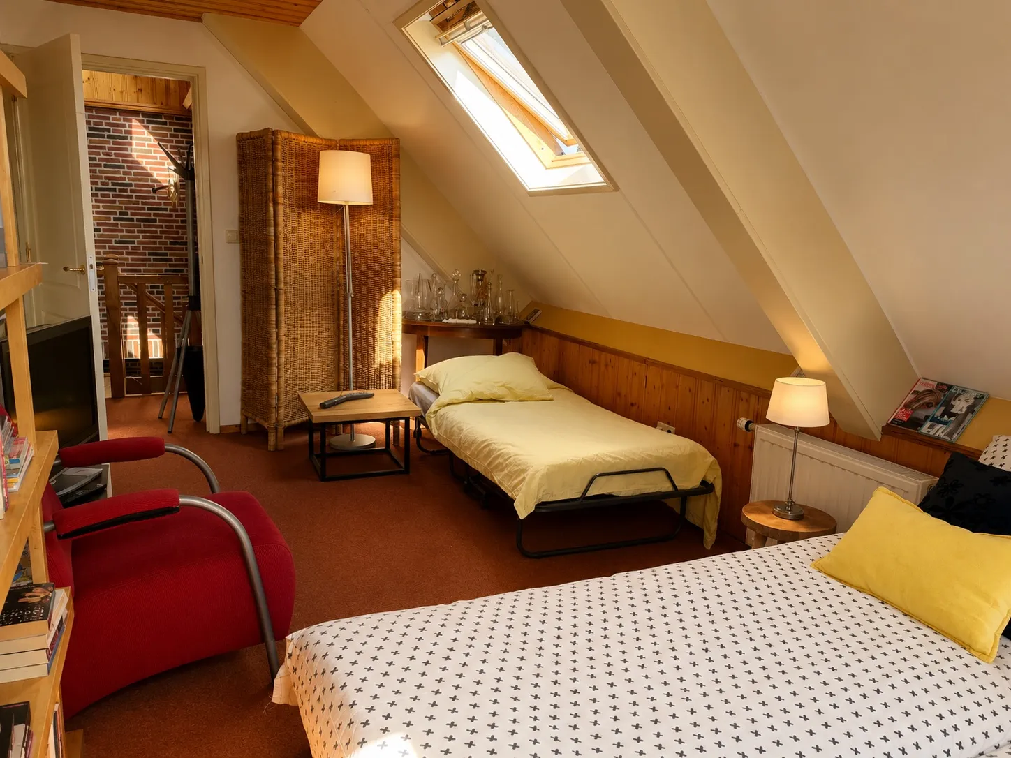Overzicht van Kamer 3 met lits-jumeaux, een extra bed en een rieten kast onder het schuine dak