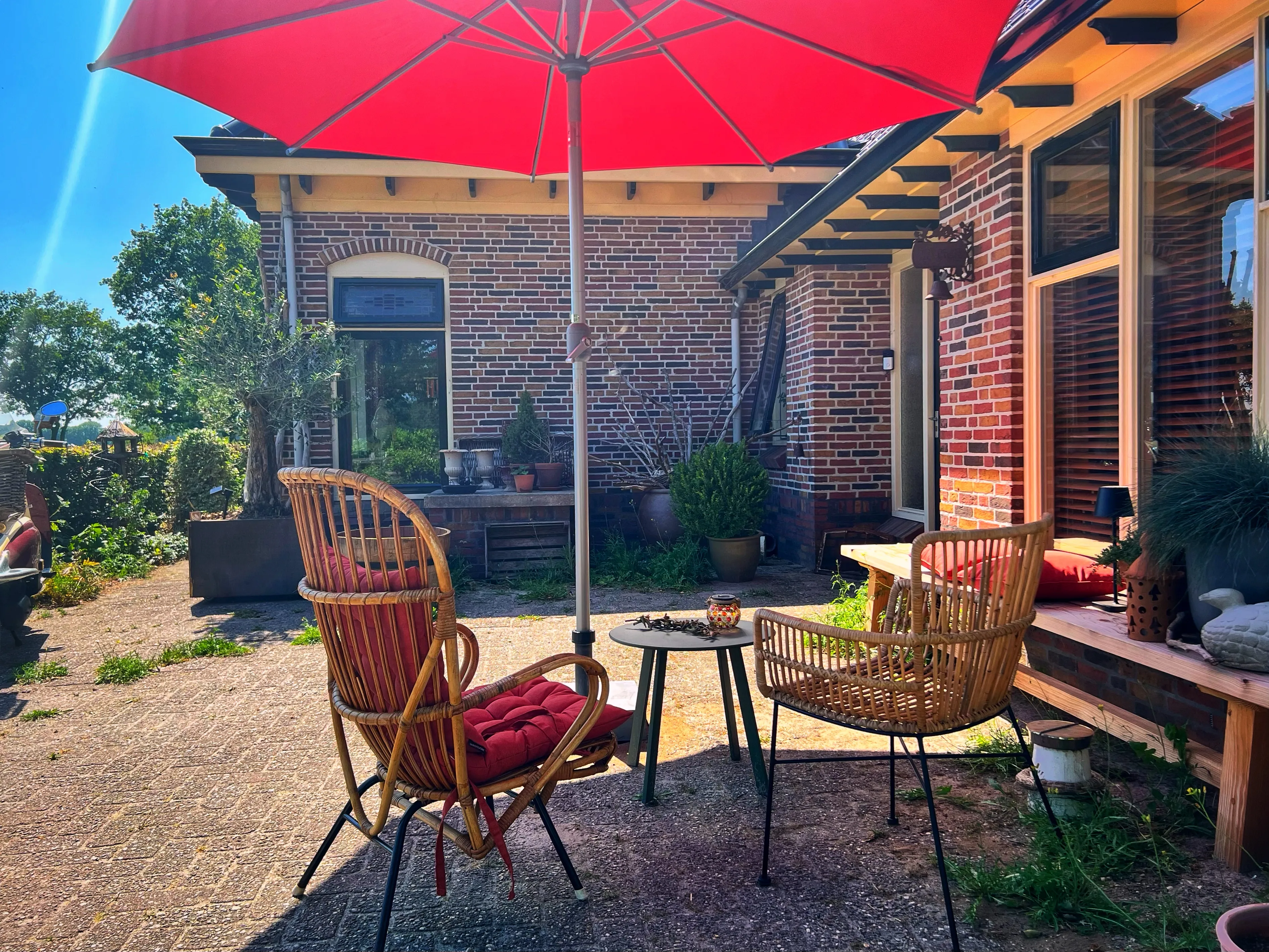 Gezellig terras met rieten stoelen en koffie op tafel bij B&B Zandhuizen